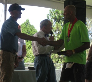 Dave collecting his belt buckle and accepting congratulations from Tim Twietmeyer, who won Western States five times among his 25 sub-24 hour finishes in the race.  